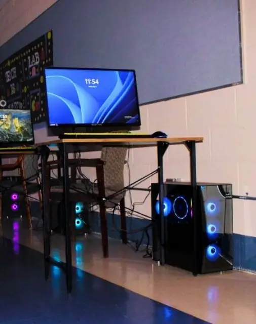 Computer stations with monitors and glowing towers in the computer lab