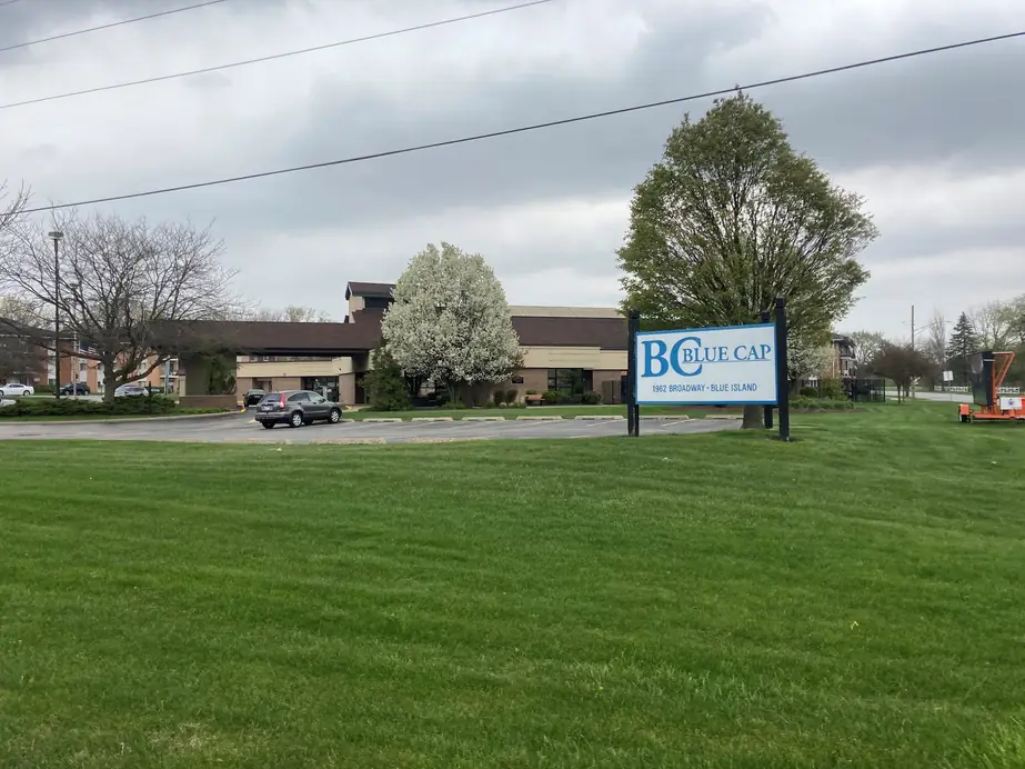 The Blue Cap campus and roadside sign across the lawn on Broadway